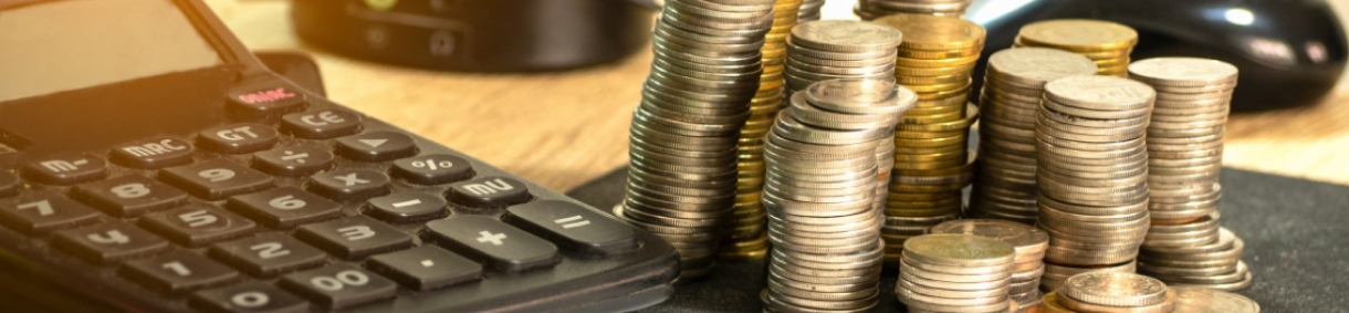 Monedas apiladas y una calculadora